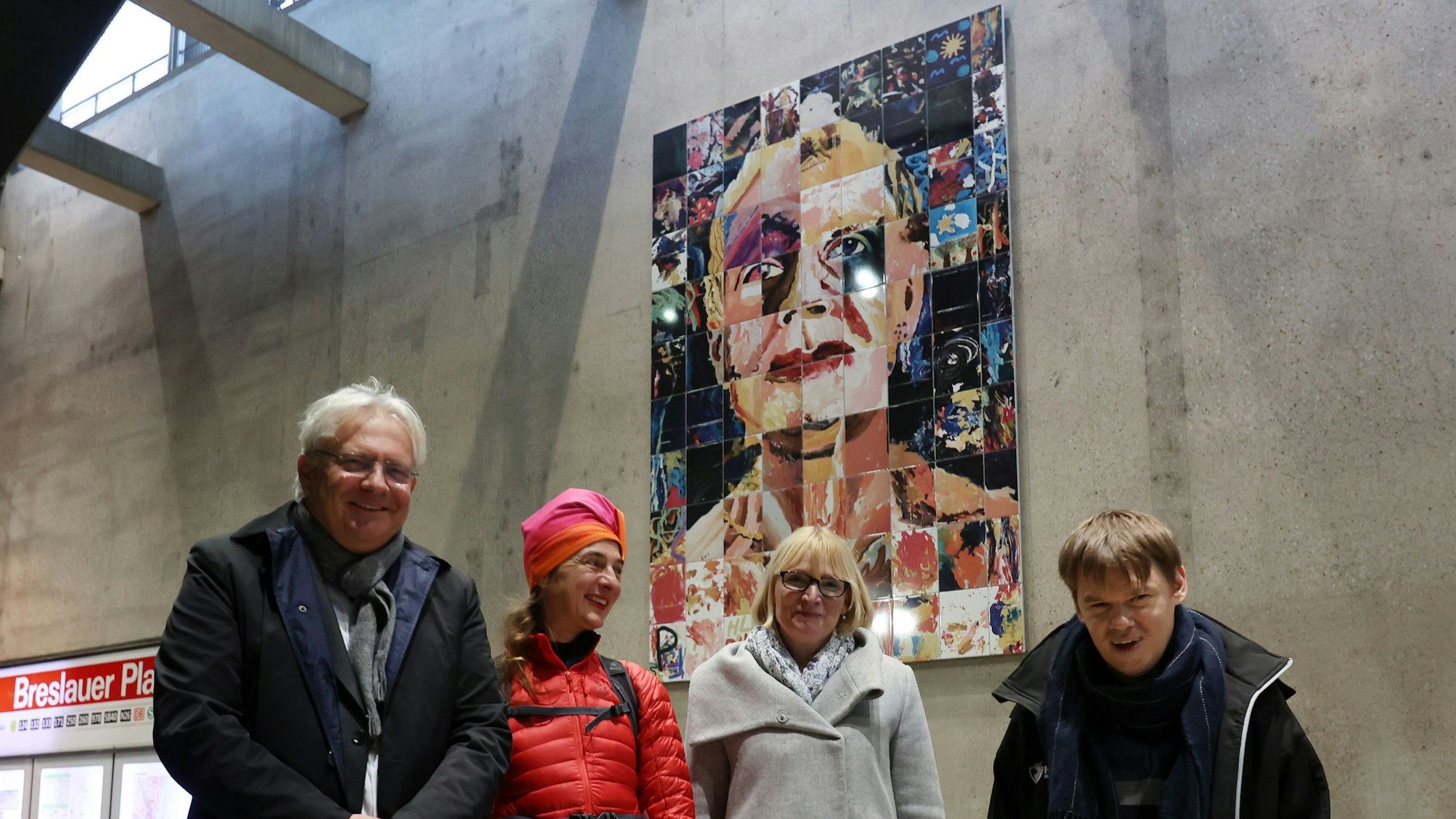 Einweihung des Kunstwerks in der Kölner U-Bahn Haltestelle Breslauer Platz mit Dr. Ralph Elster, Bürgermeister der Stadt Köln, der Kölner Künstlerin Marion Anna Simon, Stefanie Haaks, Vorstandsvorsitzende der KVB und dem Bewohner David. Im Hintergrund zu sehen ist ein größeres Bild, welches aus einzelnen Kacheln zusammengesetzt ein Porträt bildet.
