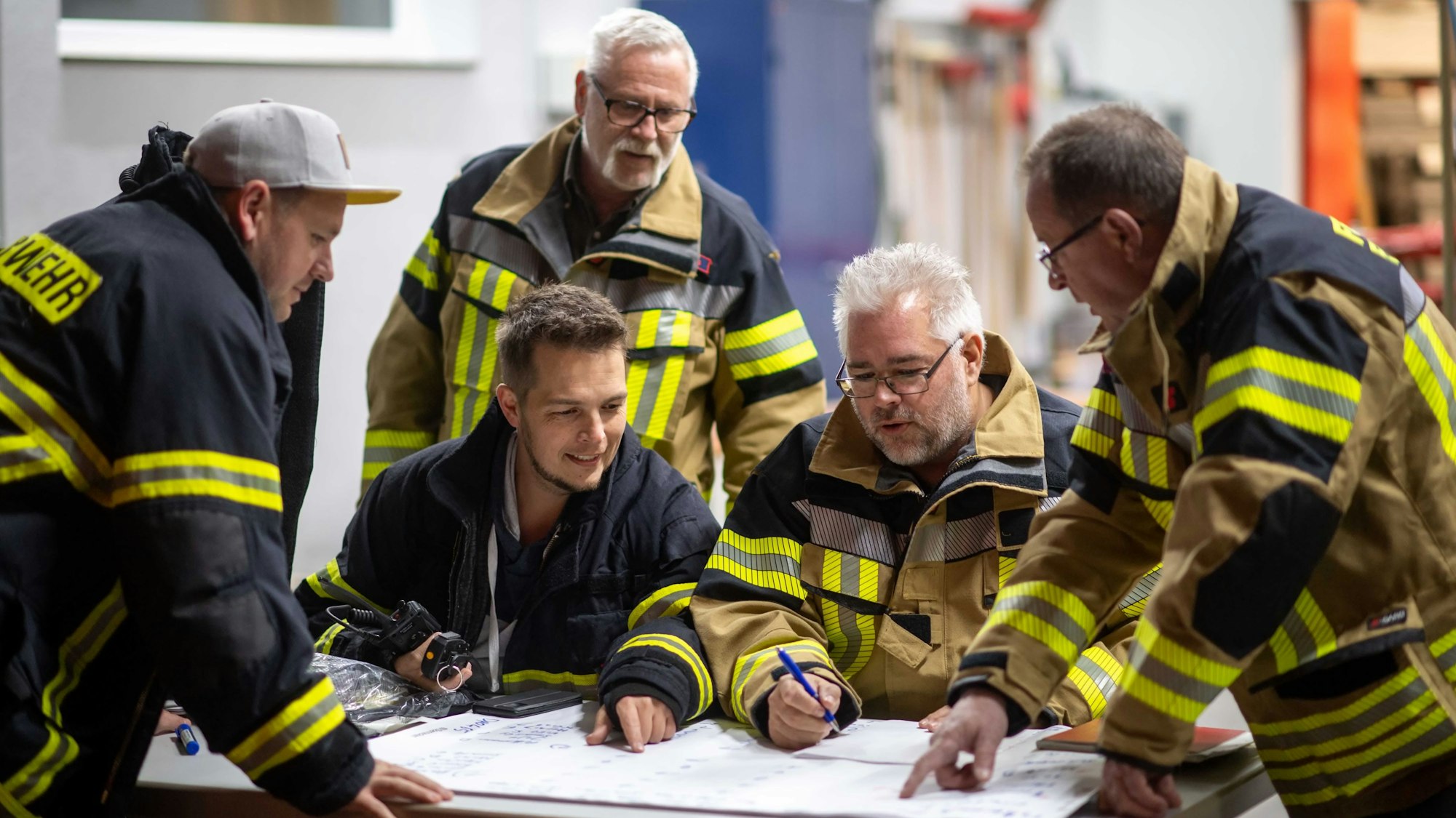 Die Feuerwehrleute der Löschgruppe Dom-Esch sitzt über einem Schichtplan zusammen.