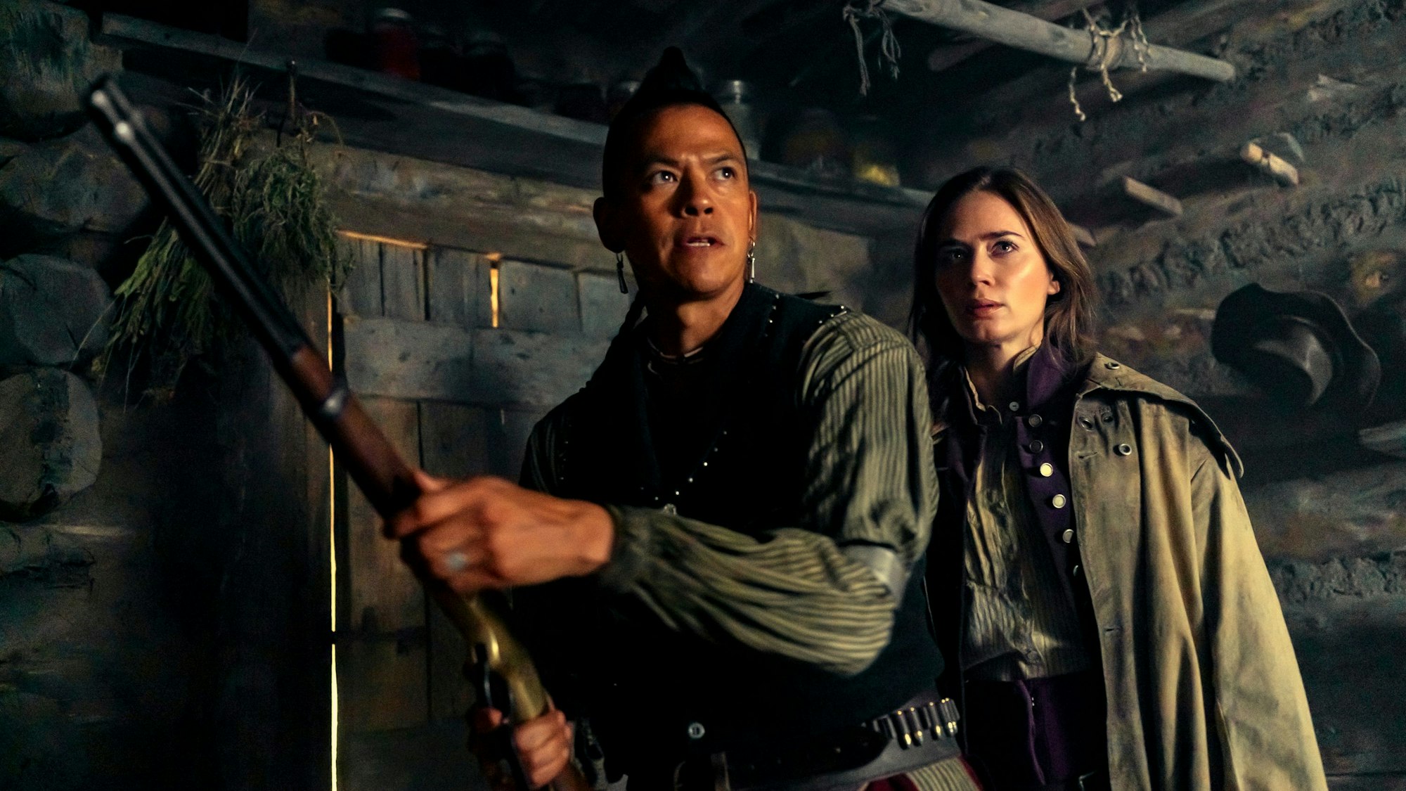 Chaske Spencerund Emily Blunt stehen in „The English“ in einer Hütte.