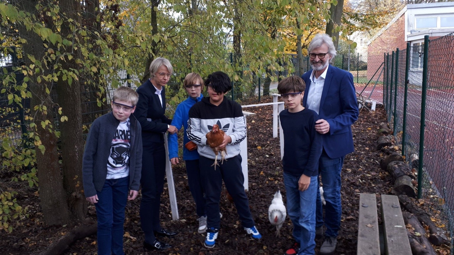Dorothee Feller (2.v.l.) und Michael Boes-Schulte (r.) mit Schülern im Hühnerstall an der Kölner Förderschule.