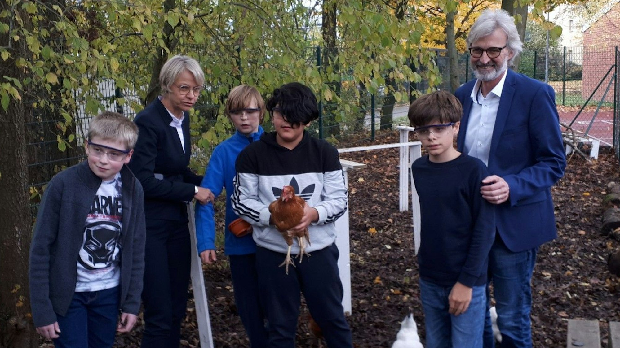 Dorothee Feller (2.v.l.) und Michael Boes-Schulte (r.) mit Schülern im Hühnerstall an der Kölner Förderschule.