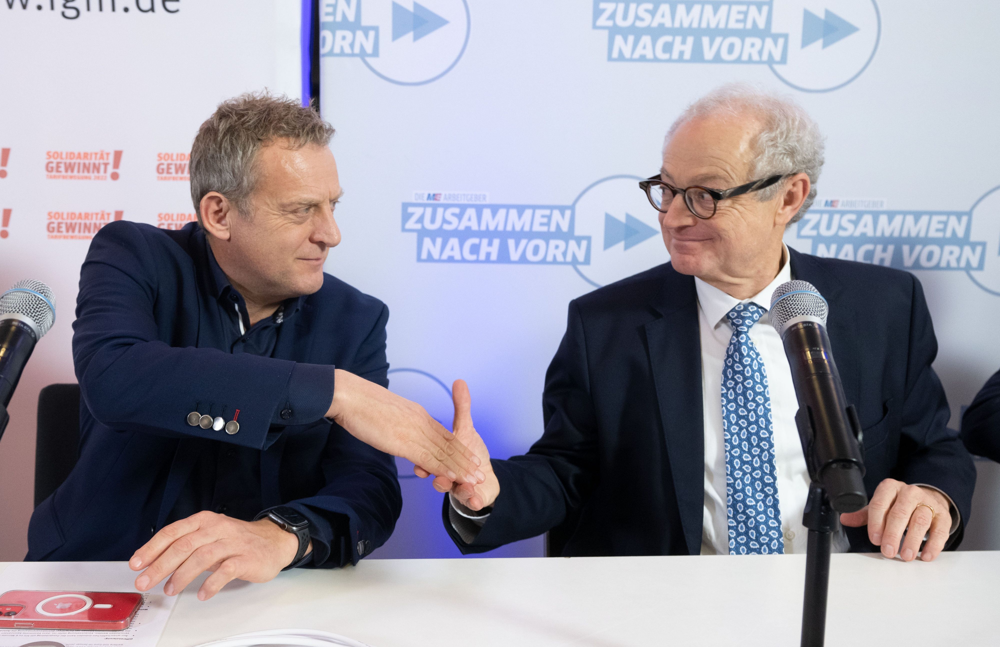 Roman Zitzelsberger (l), Bezirksleiter der IG Metall Baden-Württemberg, und Harald Marquardt, stellvertretender Vorsitzender Südwestmetall, geben sich nach einer Pressekonferenz, in der die Ergebnisse der Tarifverhandlungen der Metall- und Elektroindustrie vorgestellt wurden, die Hand.