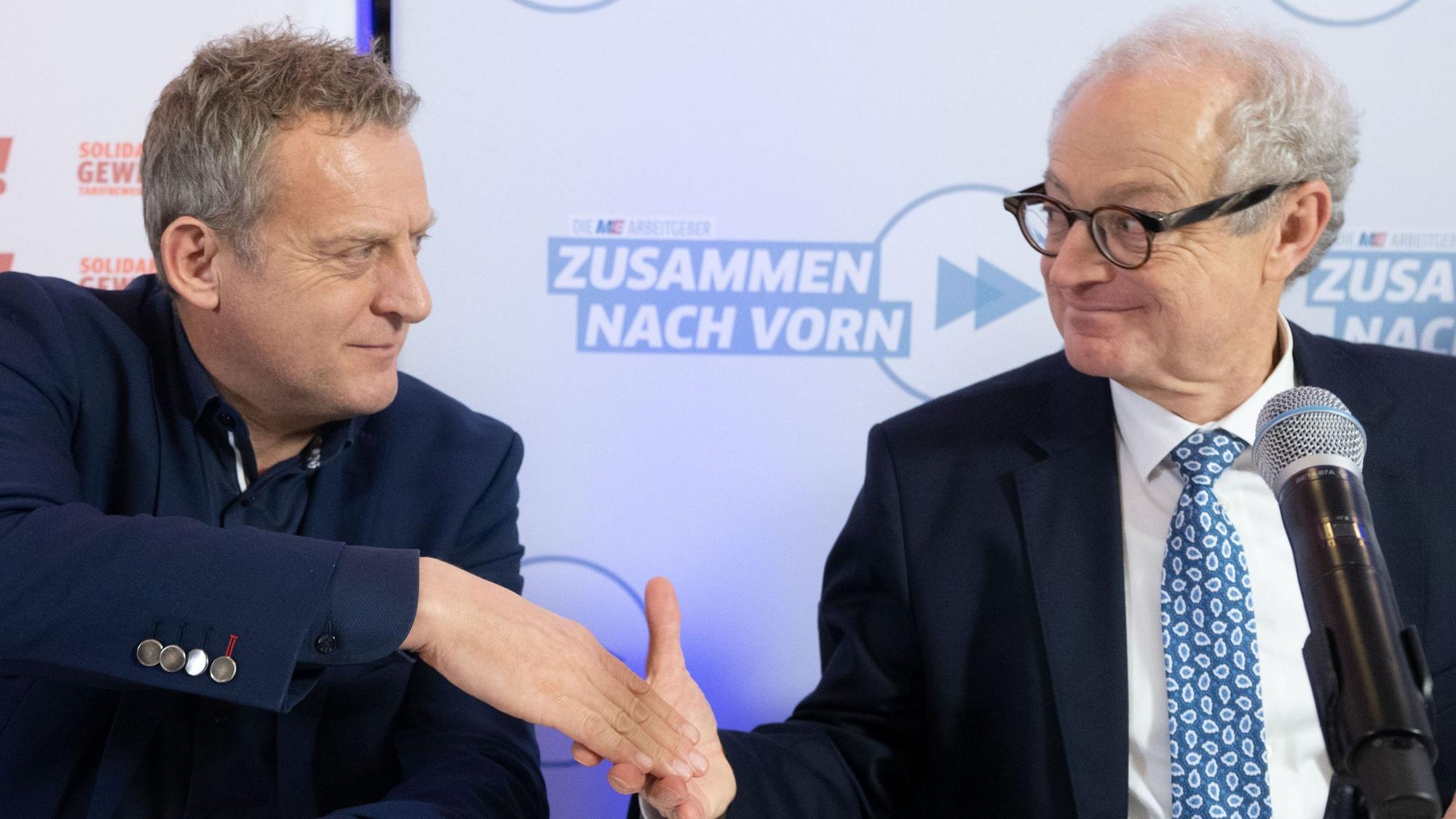 Roman Zitzelsberger (l), Bezirksleiter der IG Metall Baden-Württemberg, und Harald Marquardt, stellvertretender Vorsitzender Südwestmetall, geben sich nach einer Pressekonferenz, in der die Ergebnisse der Tarifverhandlungen der Metall- und Elektroindustrie vorgestellt wurden, die Hand.