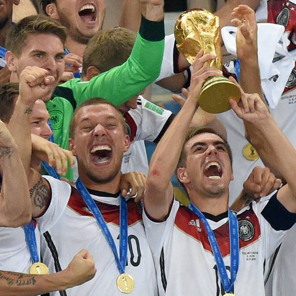 Philipp Lahm jubelt mit dem WM-Pokal zwischen seinen Teamkollegen Lukas Podolski und Thomas Müller