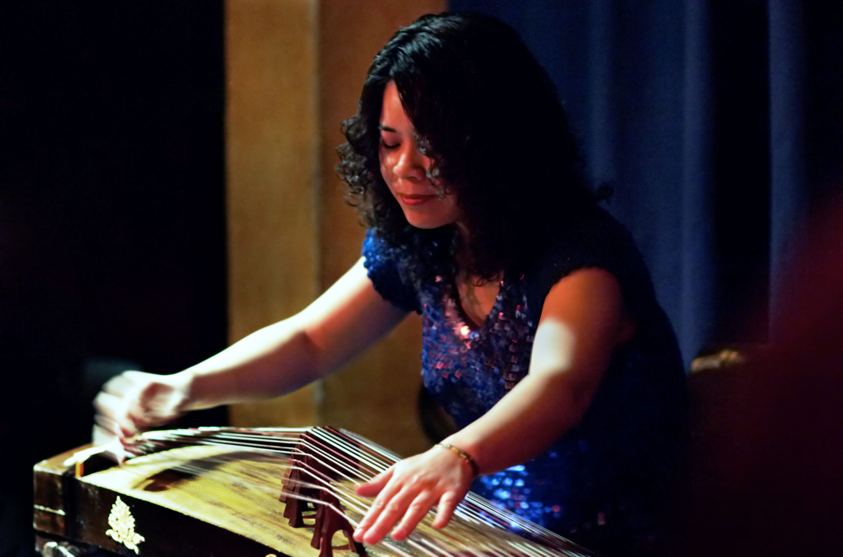 Die chinesische Musikerin Xu Fengxia spielt auf einer Guzheng, einem liegenden Instrument mit sieben Saiten.