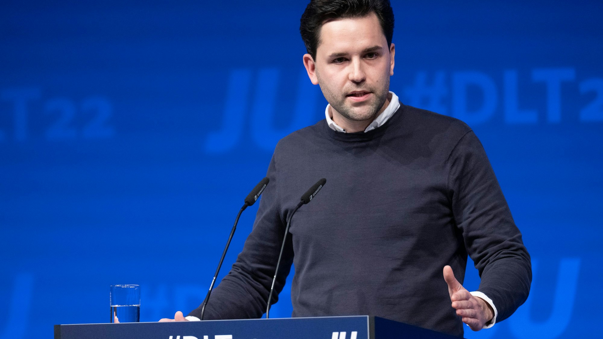 Joahnnes Winkel, gekleidet mit Hemd und Pullover darüber, an einem Rednerpult.