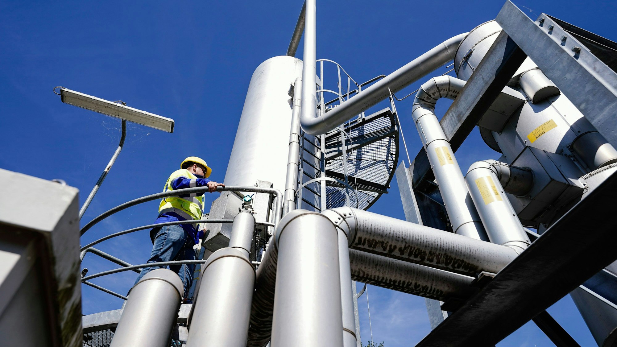 Rheinland-Pfalz, Frankenthal: Ein Mitarbeiter steht auf dem Gelände eines Gasspeichers auf einer Absorber-Anlage.