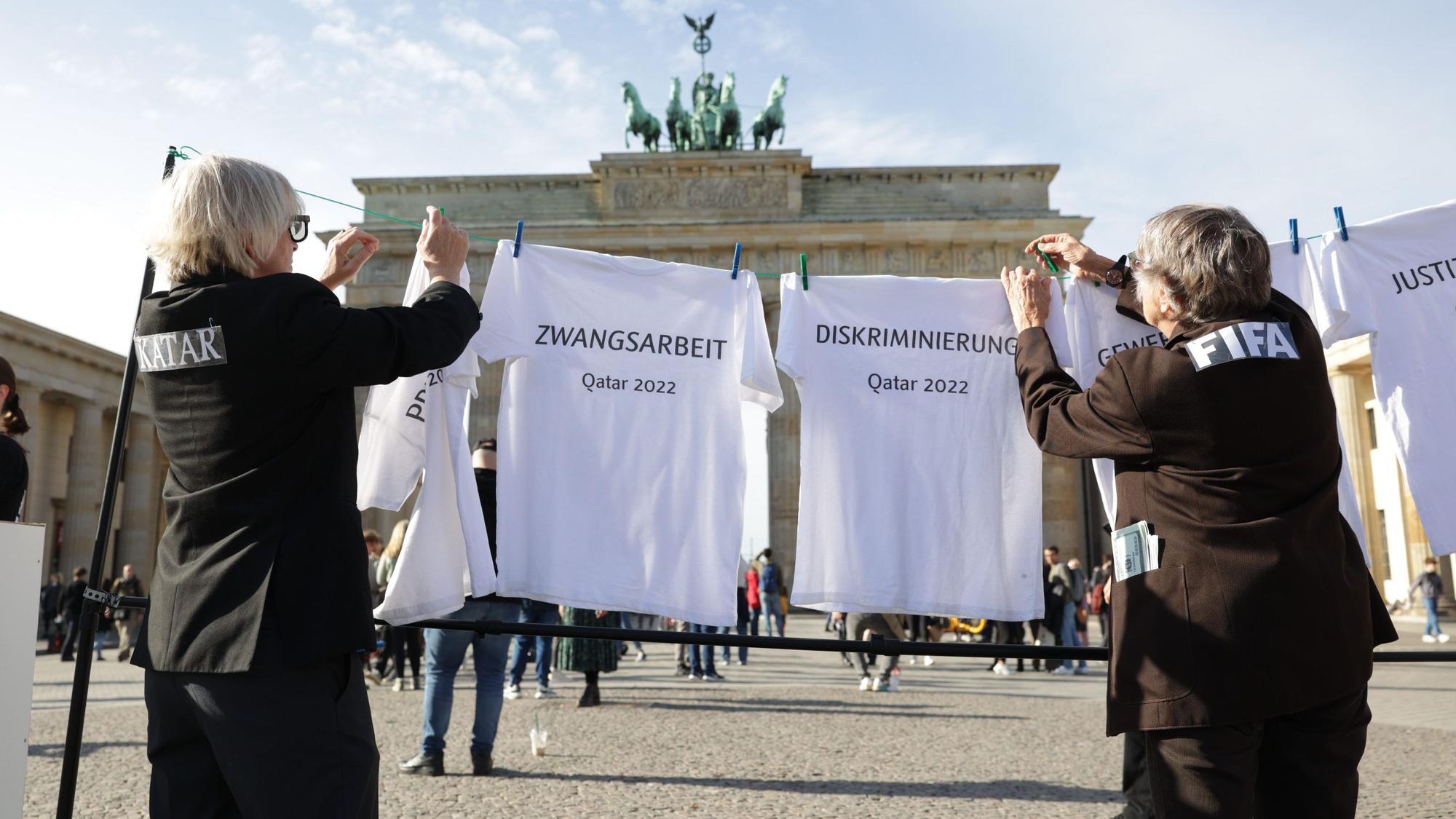 Bei einer Kunstaktion von Amnesty International hängen Schauspieler T-Shirts, auf denen Begriffe wie Pressezensur, Zwangsarbeit, Diskriminierung, Gewerkschaftsverbot und Justizwillkür stehen, an eine Wäscheleine vor dem Brandenburger Tor.
