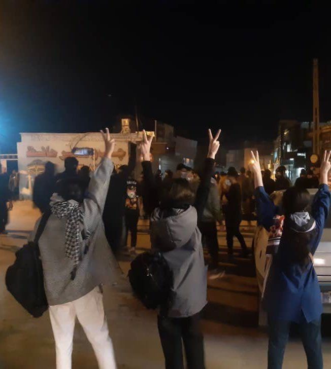 Protestierende Frauen ohne das vorgeschriebene Kopftuch heben ihre Hände und zeigen das Victory-Zeichen.