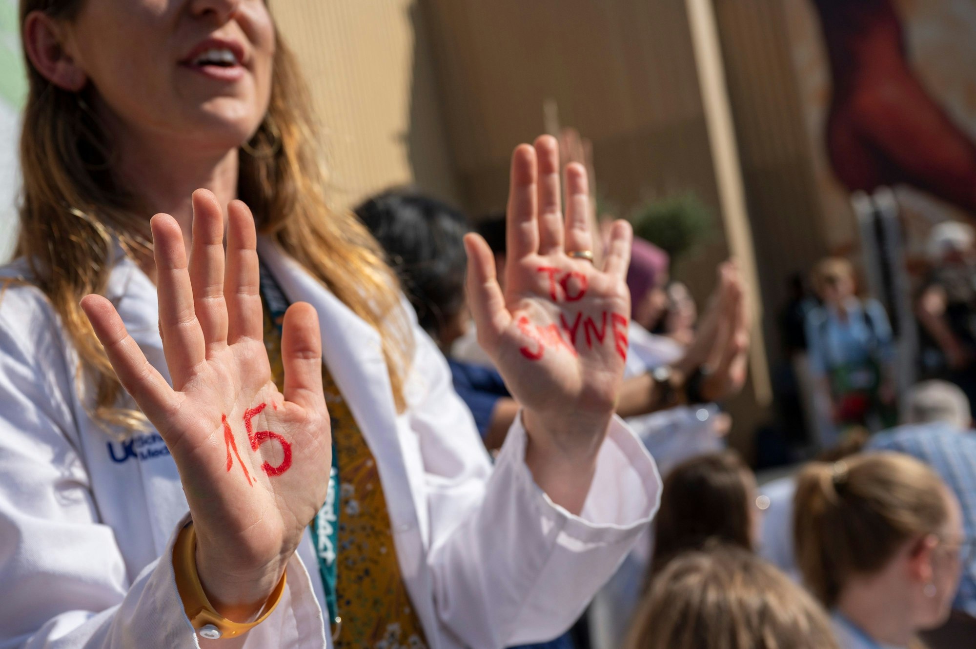 Eine Teilnehmerin bei einer Demonstration für das 1,5 Grad Ziel von Ärzten und Medizinstudenten aus mehreren Ländern beim UN-Klimagipfel COP27 hat sich mit roter Farbe „1.5 to survive“ auf die Hände gemalt.