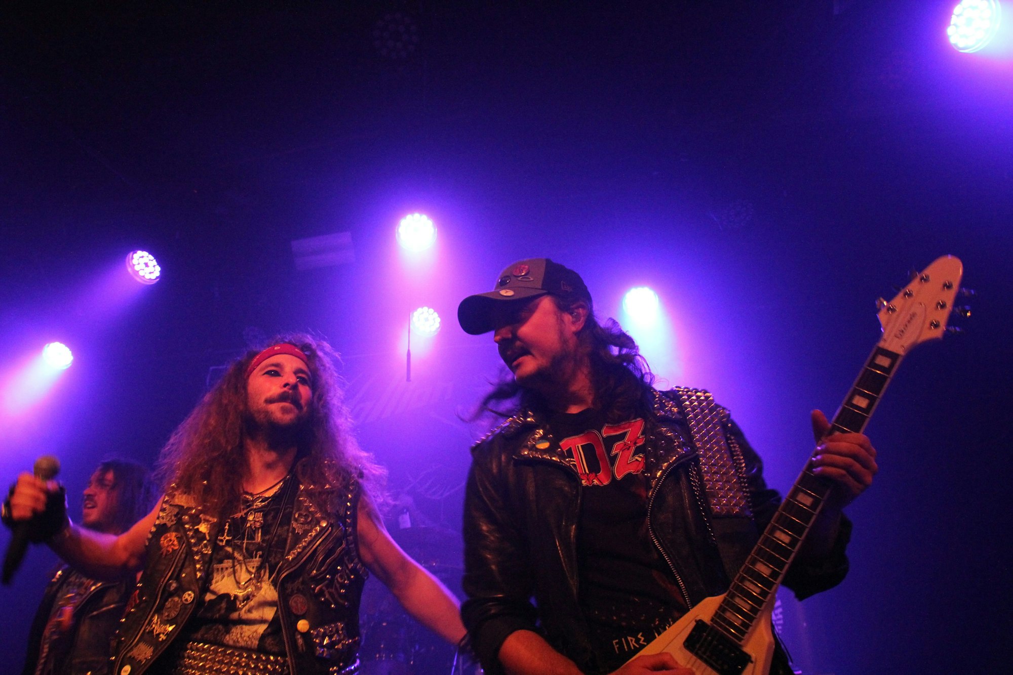 Ein Gitarrist spielt sein Solo, während der Sänger innehält.