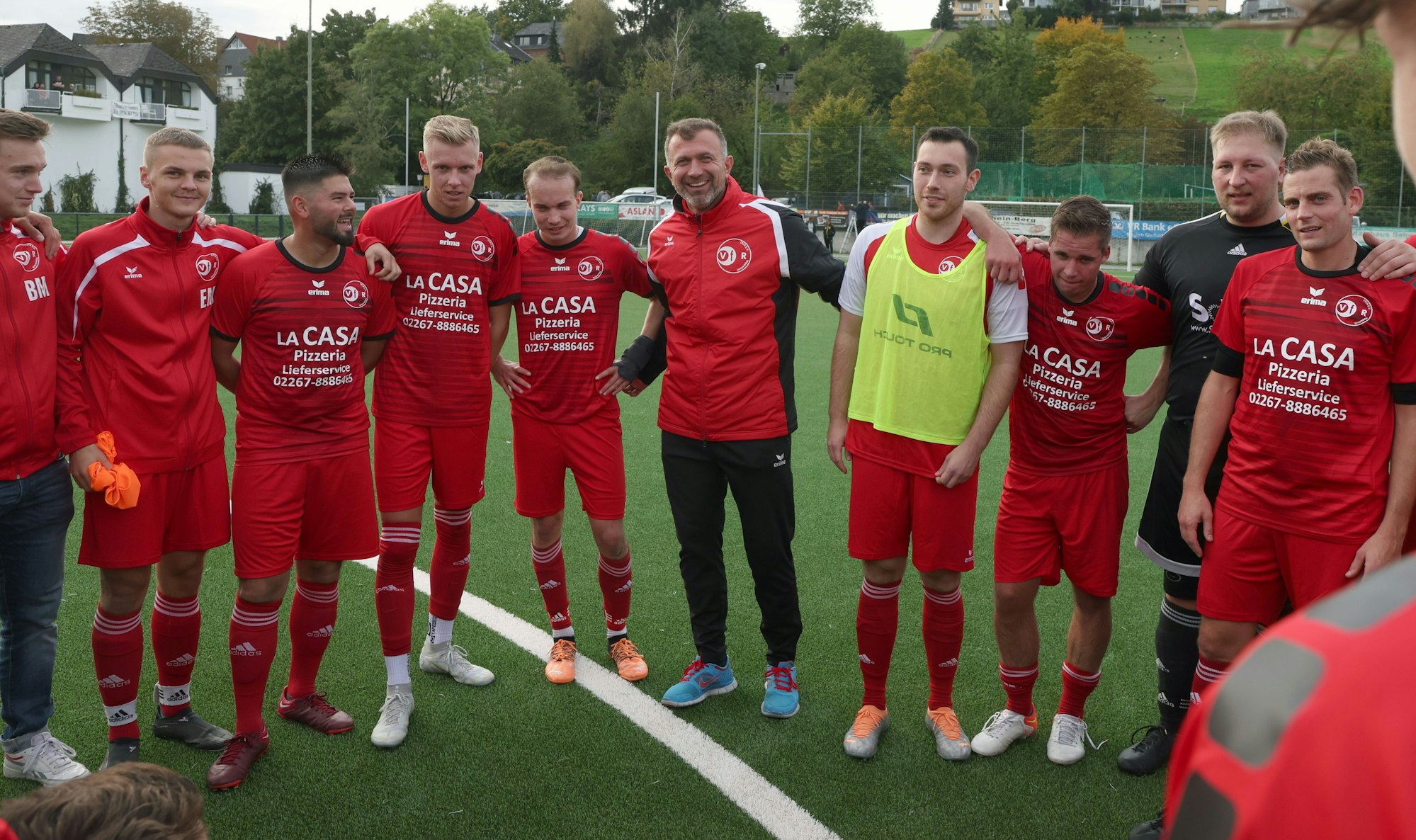 Teile des VFR Wipperfürth stehen mit Trainer Bernardo auf dem Platz.