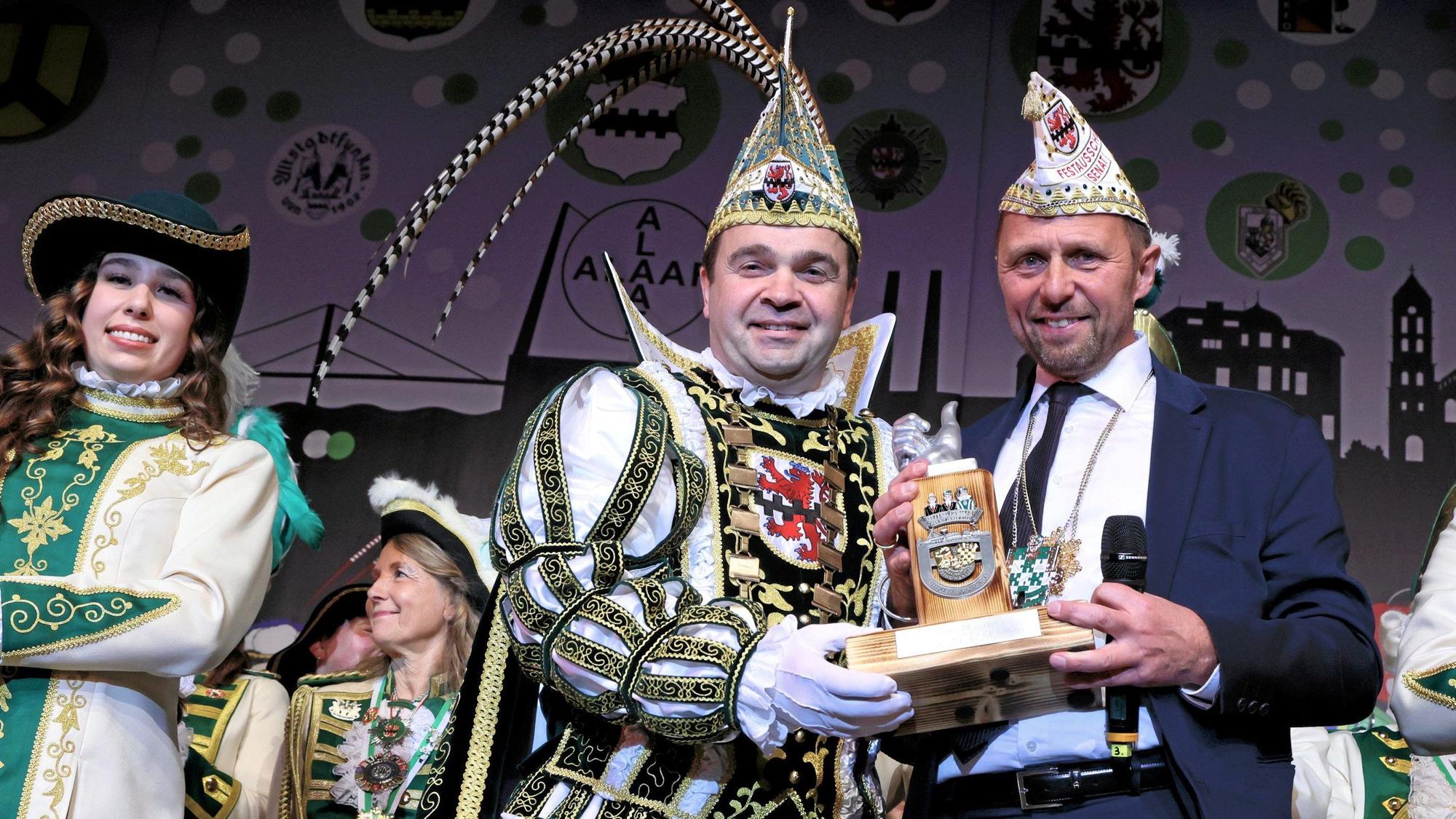 Oberbürgermeister Uwe Richrath überreicht Prinz Marijo eine Ordens-Skulptur mit „Daumen hoch“.