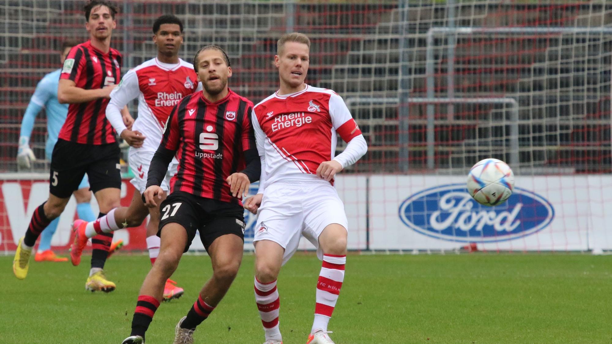 Ein Fußballspieler bedrängt seinen Gegner im Zweikampf und versucht, ihn den Ball wegzuspielen.