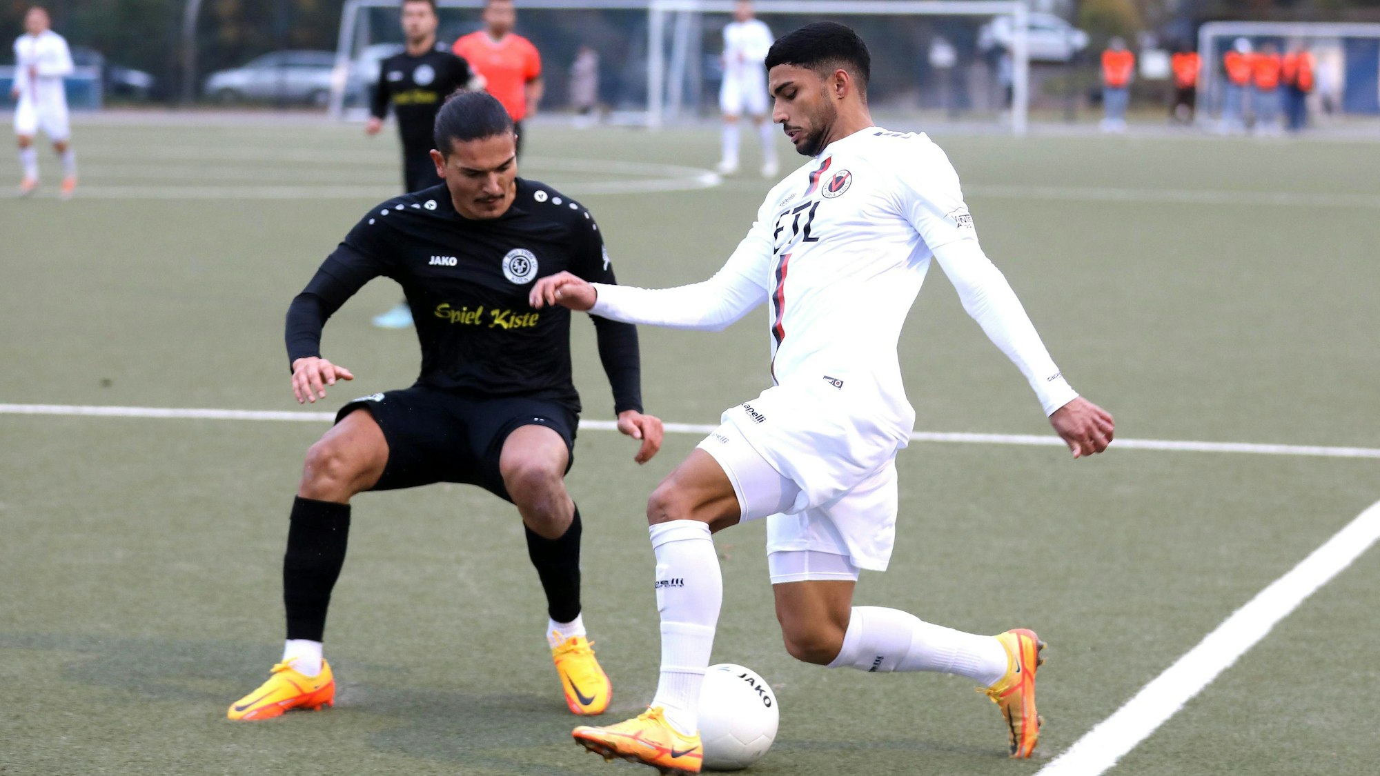 Ein Fußballspieler versucht, im Zweikampf an seinem Gegner vorbeizukommen.