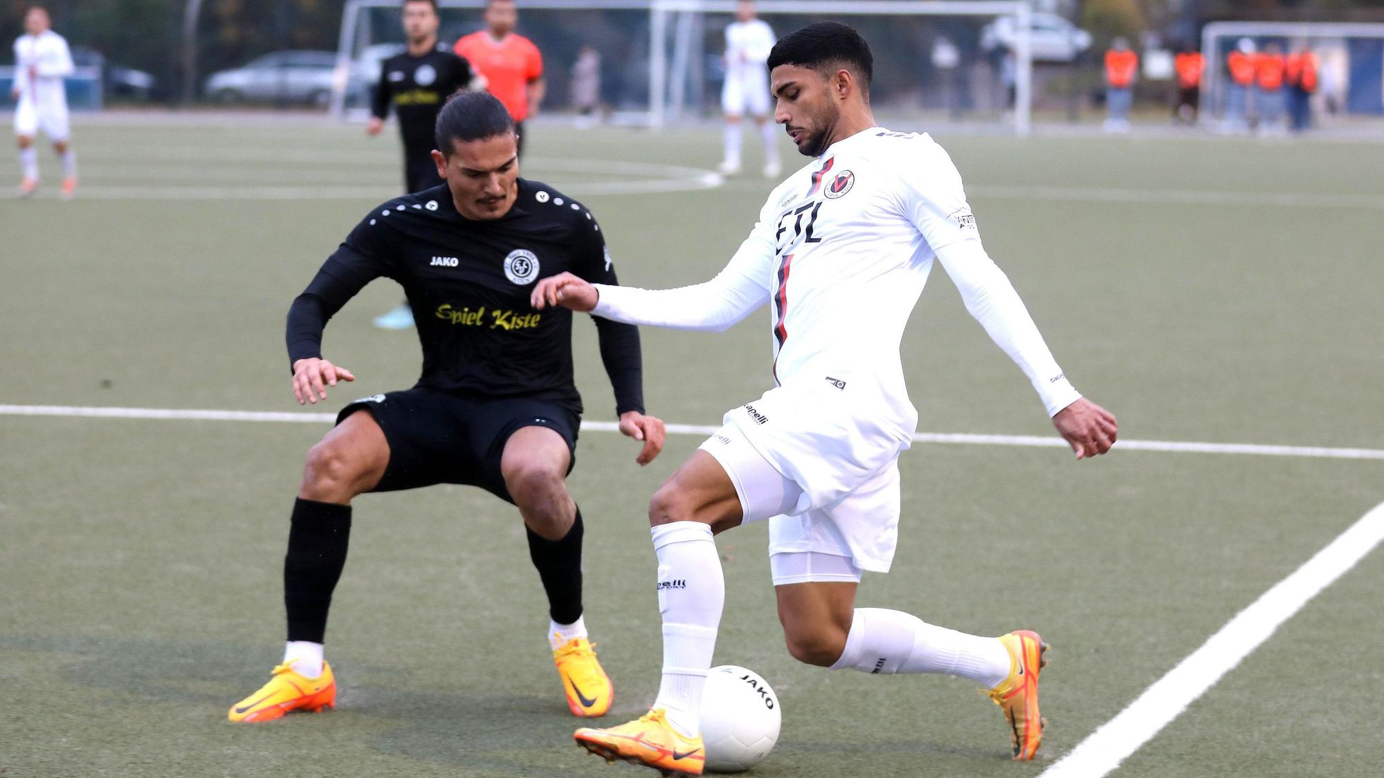 Ein Fußballspieler versucht, im Zweikampf an seinem Gegner vorbeizukommen.