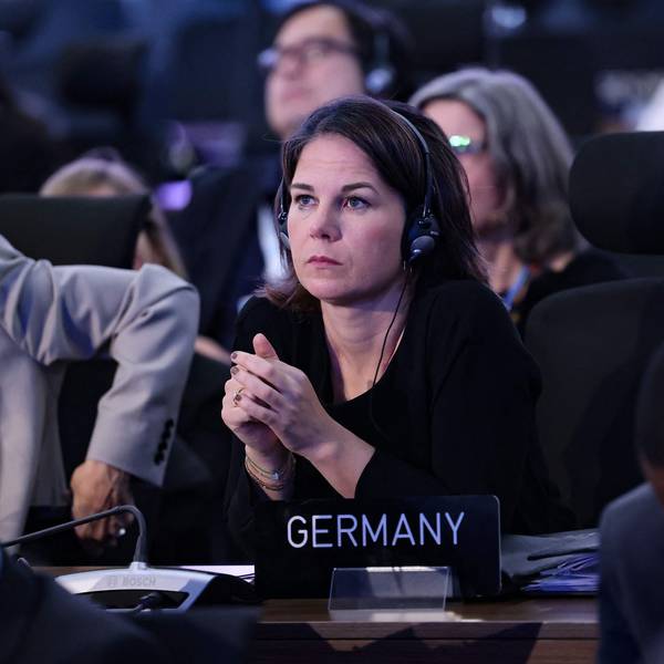 Bundesaußenministerin Annalena Baerbock (Grüne) schaut skeptisch und hat in einem Konferenzsaal Kopfhörer auf. Vor ihr steht ein Schild, auf dem „Germany“ steht.