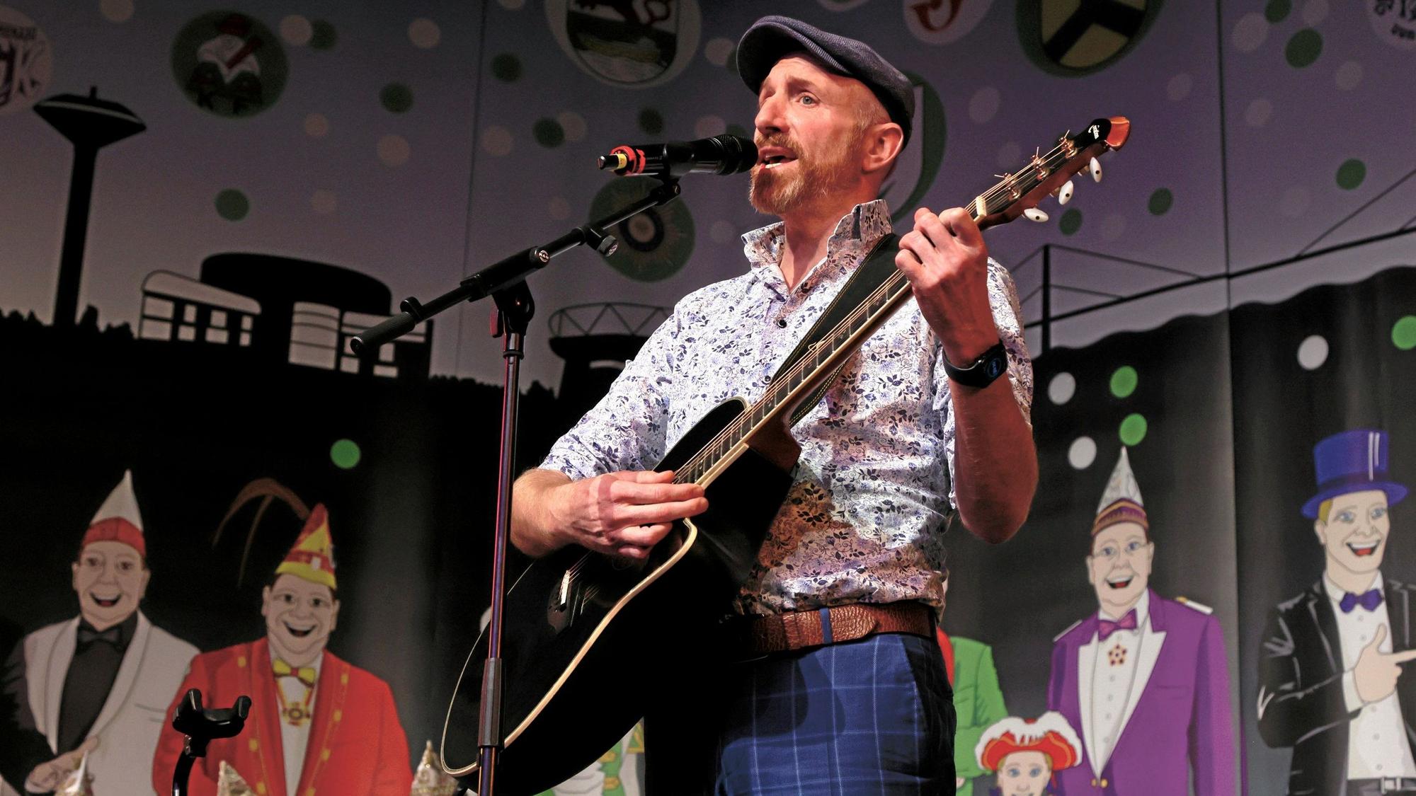 Büttenredner und Krätzchensänger Martin Schopps mit Gitarre beim Auftritt im Forum