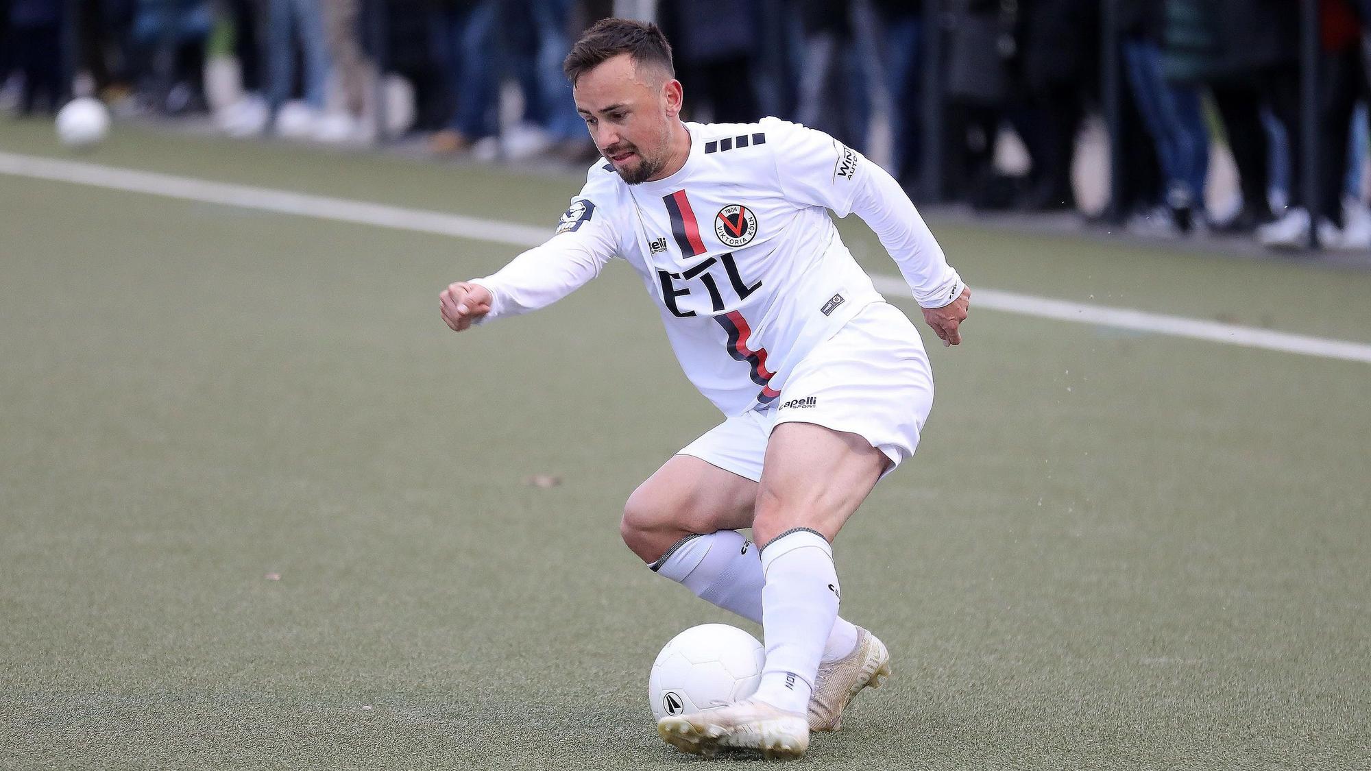 Ein Fußballspieler führt den Ball mit dem linken Fuß.