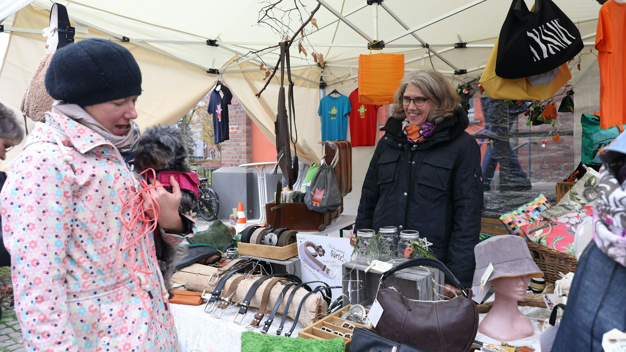 Eine Kundin schaut sich Ware im Stand von Sabine Strippel an.