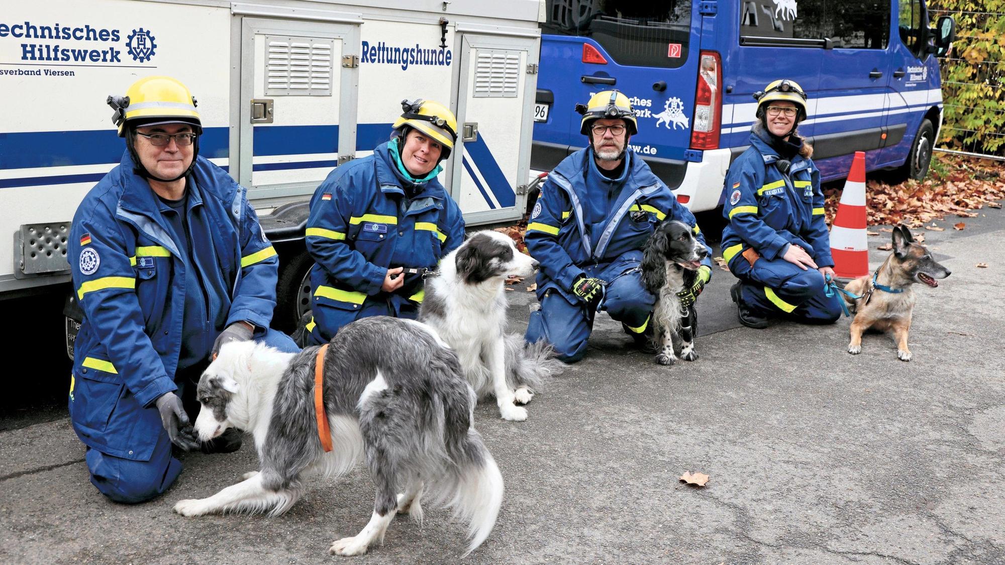 Vier THW-Ehrenamtliche mit ihren Hunden.