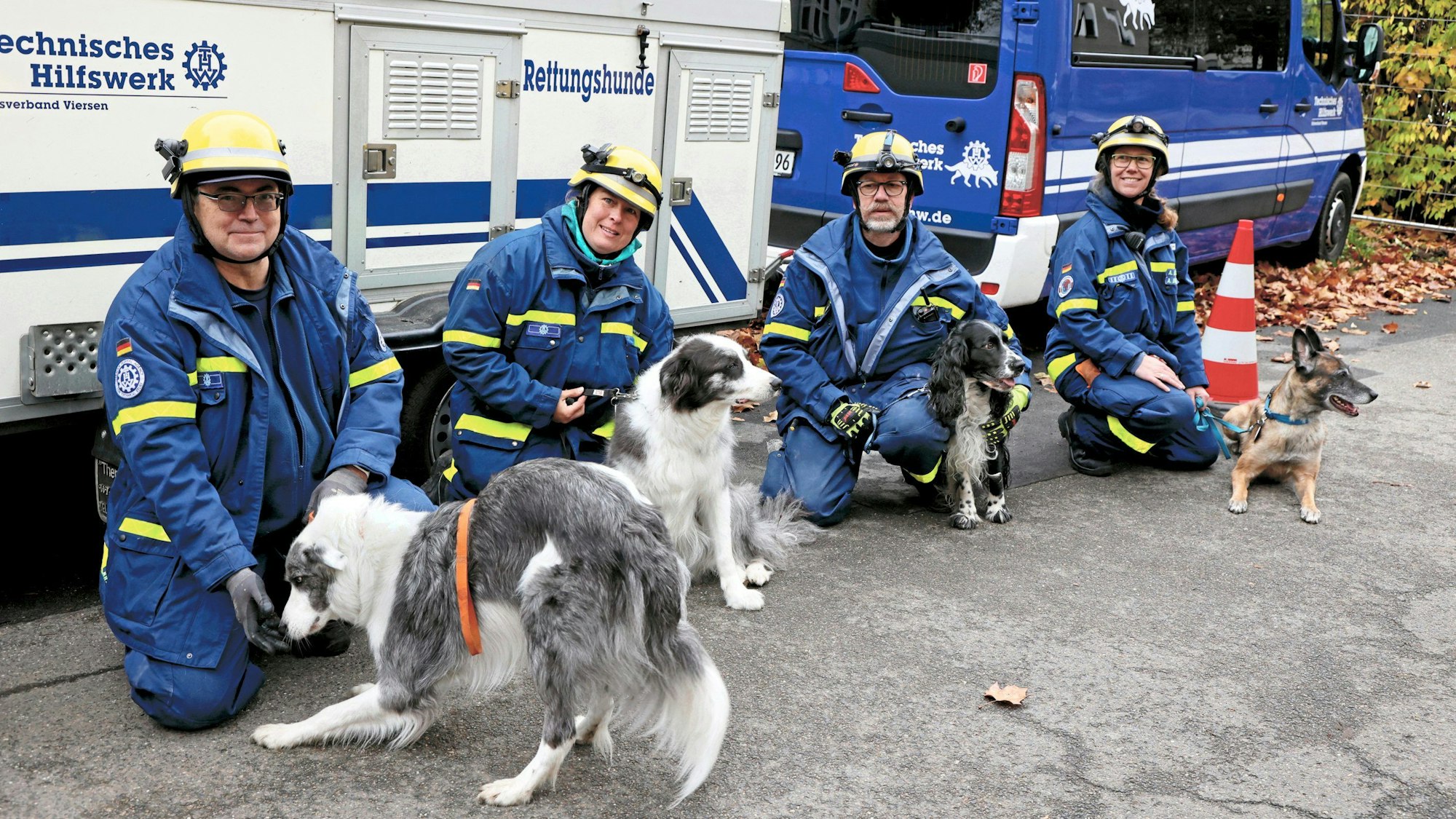Vier THW-Ehrenamtliche mit ihren Hunden.