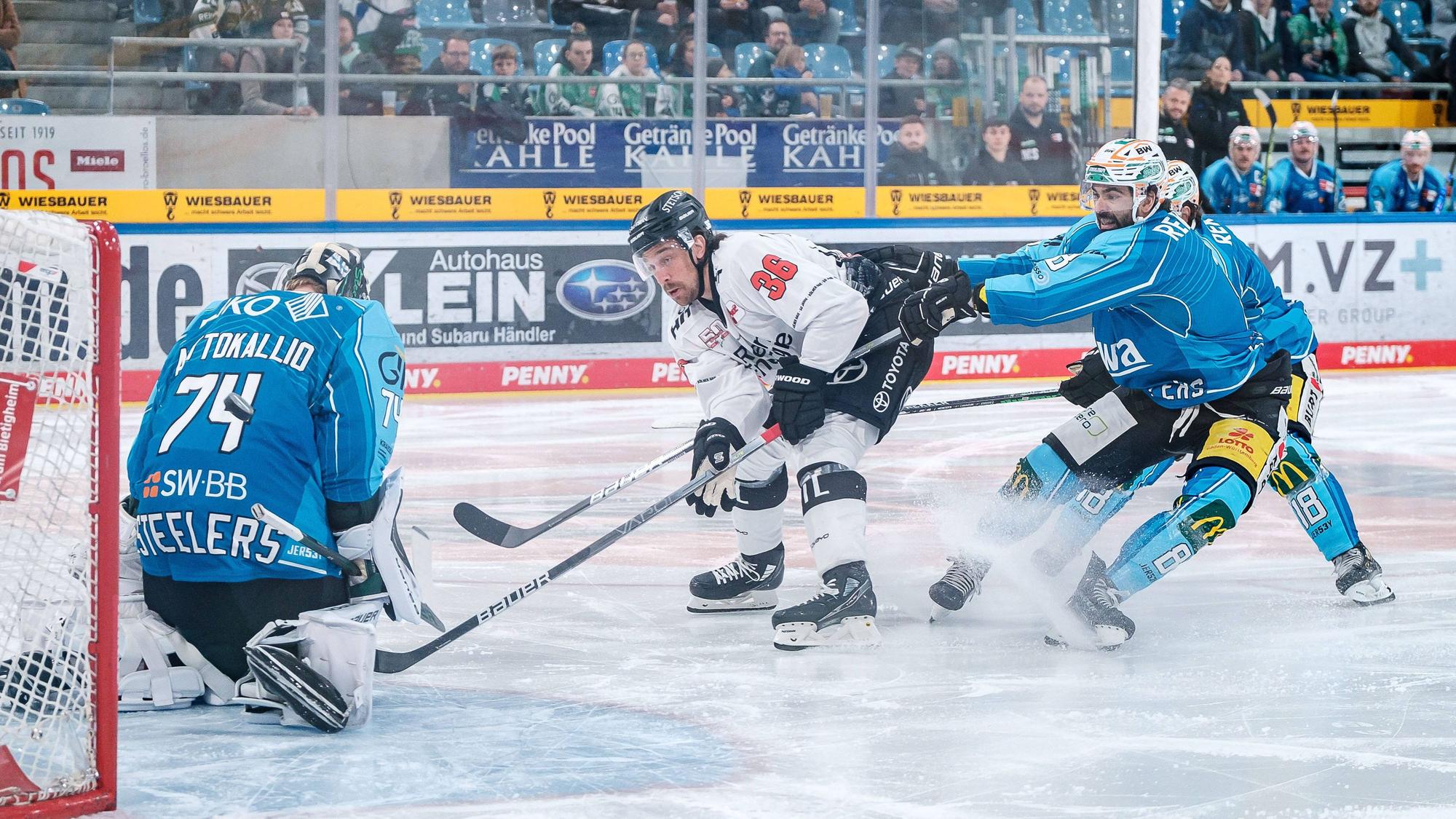 Andreas Thuresson von den Kölner Haien Bietigheims spielt zwei Verteidiger aus und schiebt den Puck an Bietigheims Torhüter Sami Aittokallio vorbei.