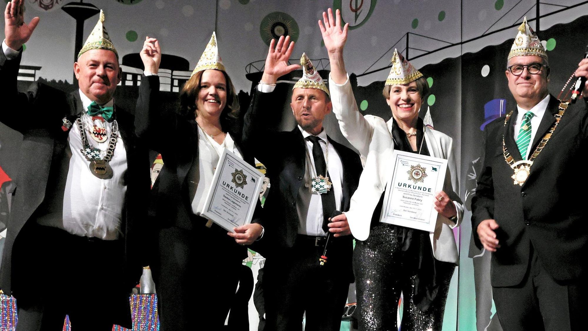 Die neuen Ehrensenatorinnen des FLK, Saskia Lagemann und Susanne Fabry, mit Urkunden und Narrenkappen auf der Bühne
