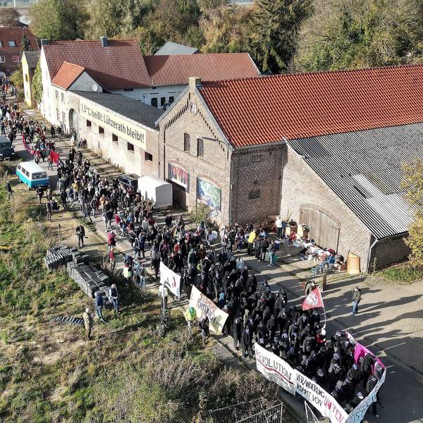 Lützerath von oben gesehen: Bei einer Demonstration in Lützerath ziehen mehrere Hundert Teilnehmer mit Banner durch das Dorf.