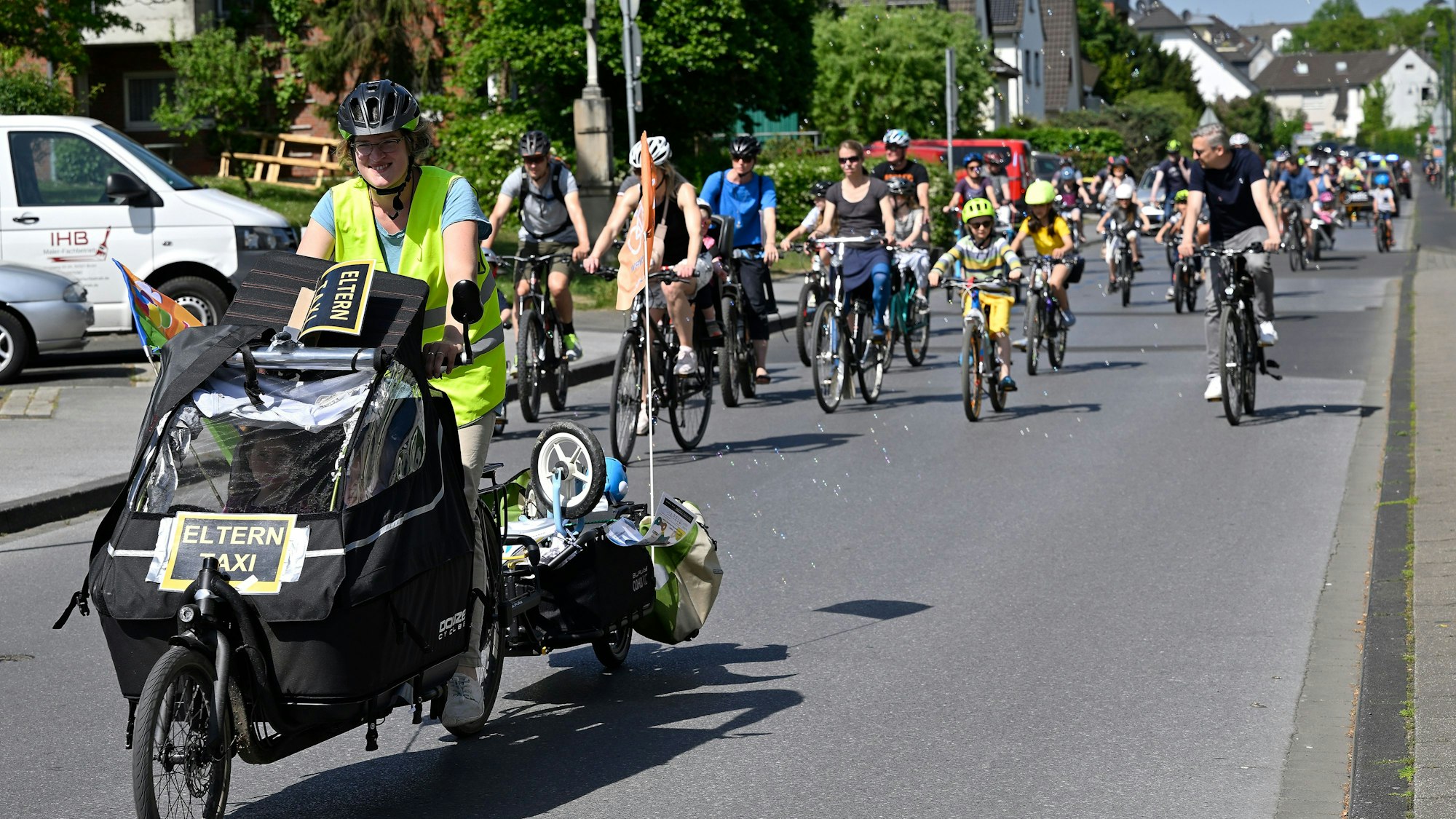 Erwachsene und Kinder fahren mit ihren Rädern über eine Straße.