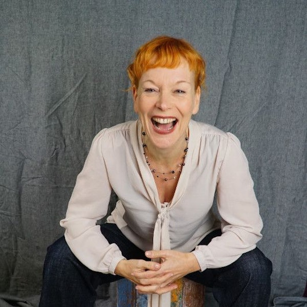 Schauspielerin Britta Weyers sitzt auf einem bunt bemalten Holzhocker.