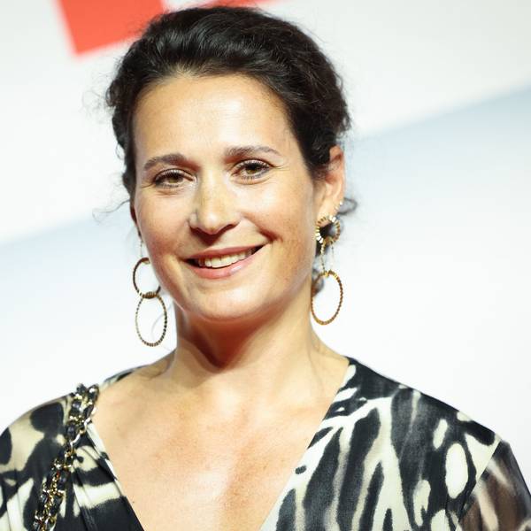 Ulrike Handel, Vorständin bei Axel Springer SE, steht vor einem weißen Hintergrund mit rotem Aufdruck.