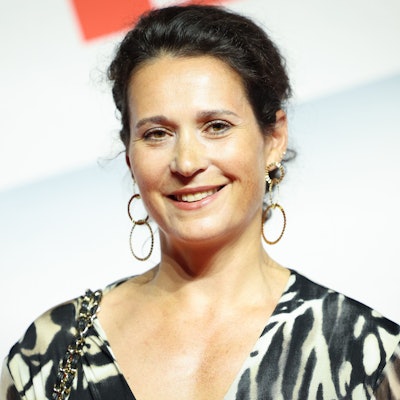 Ulrike Handel, Vorständin bei Axel Springer SE, steht vor einem weißen Hintergrund mit rotem Aufdruck.