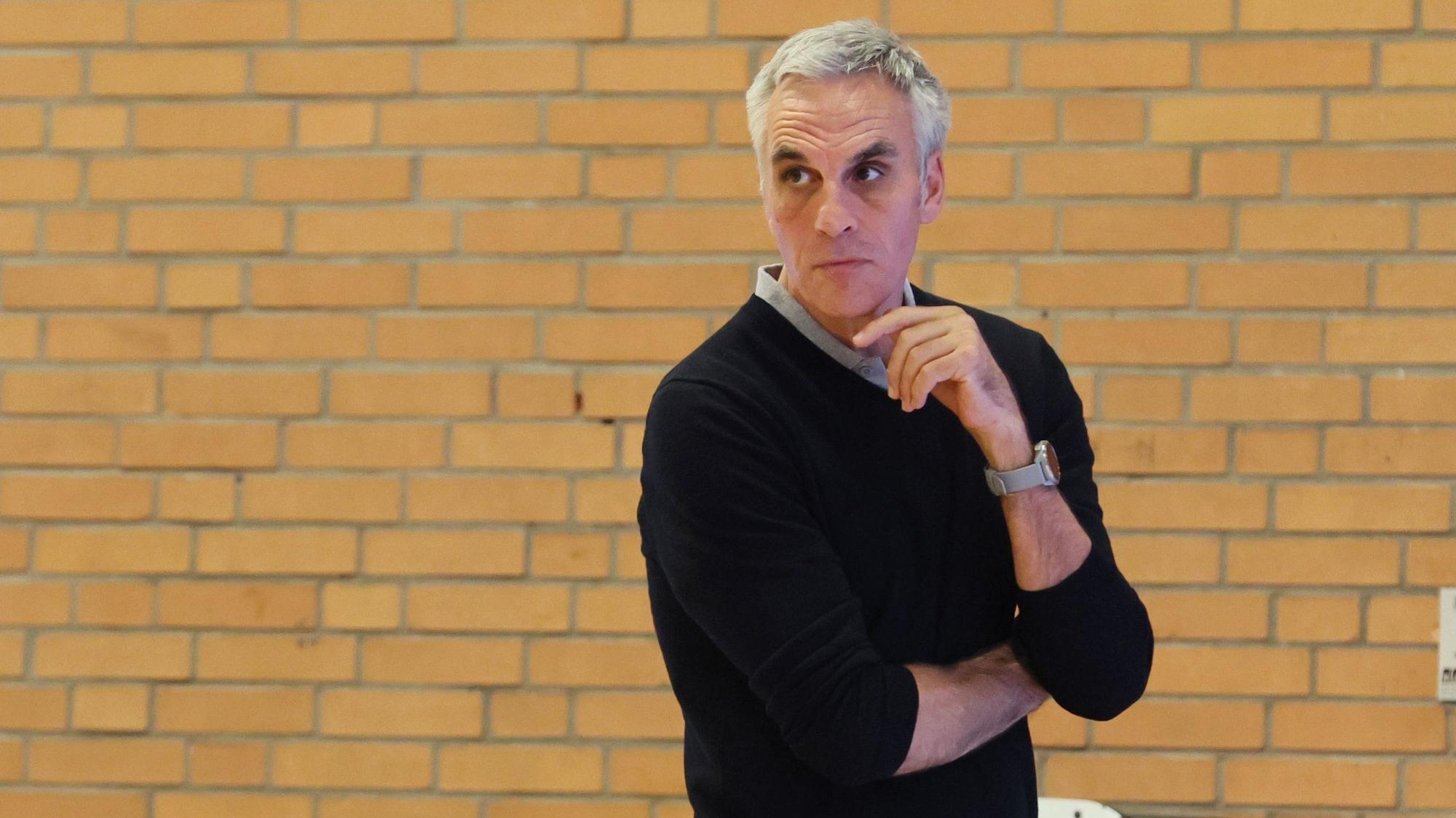 Ein Basketballtrainer steht am Spielfeldrand und schaut nachdenklich.