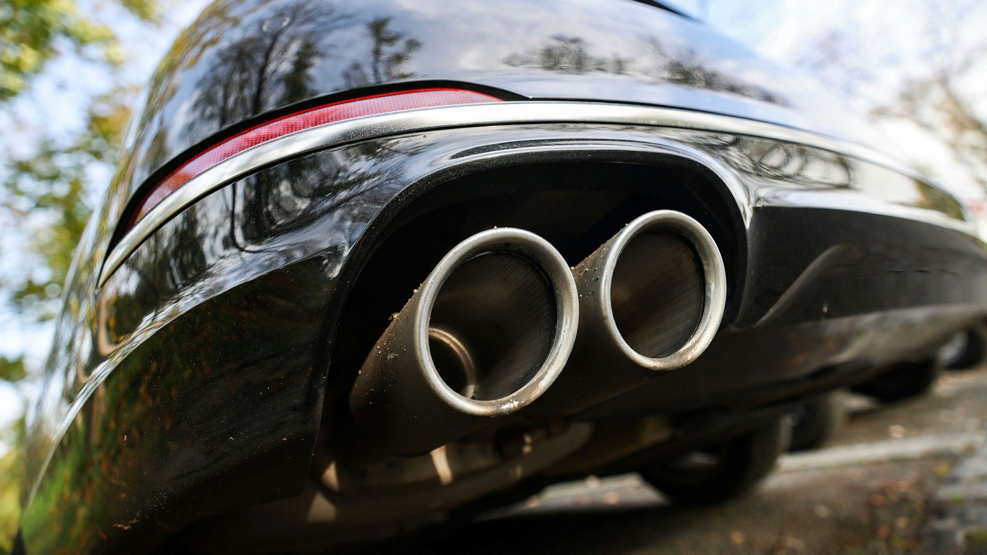 Ein Pkw mit doppeltem Auspuff steht auf einem Parkplatz.