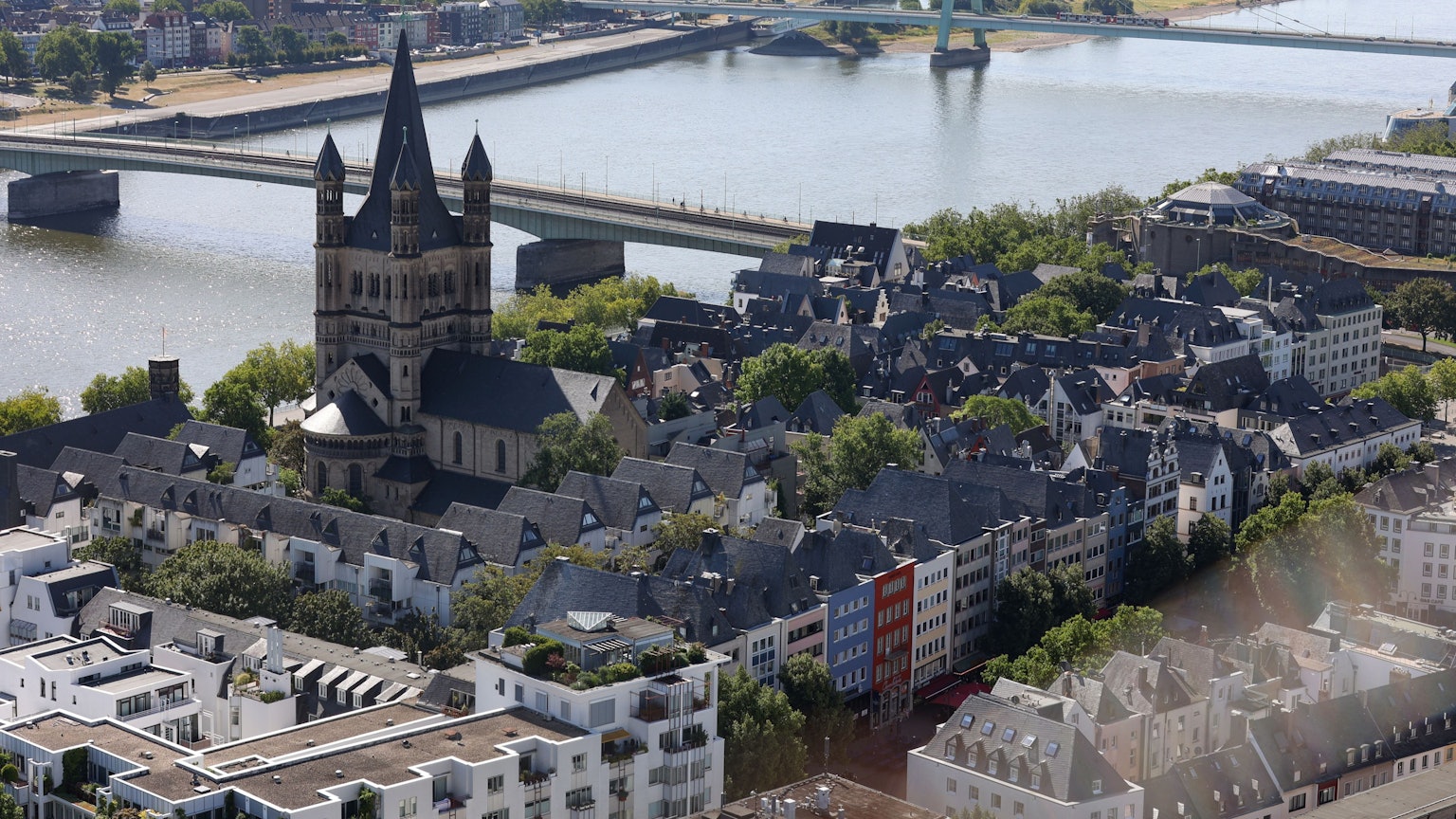 Das Bild zeigt Köln vom Dom aus fotografiert. Es sind unter anderem die Kirche Groß Sankt Martin, die Altstadt und die Deutzer Brücke
zu sehen.