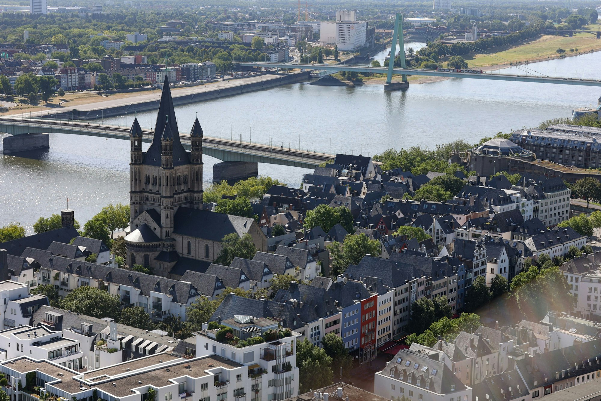 Das Bild zeigt Köln vom Dom aus fotografiert. Es sind unter anderem die Kirche Groß Sankt Martin, die Altstadt und die Deutzer Brücke
zu sehen.