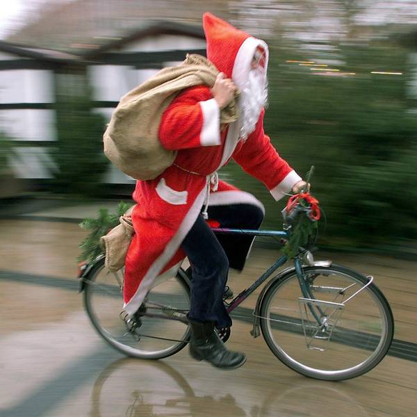 Mit rasantem Tempo fährt ein als Nikolaus verkleideter Mann auf seinem Fahrrad durch eine Fußgängerzone.