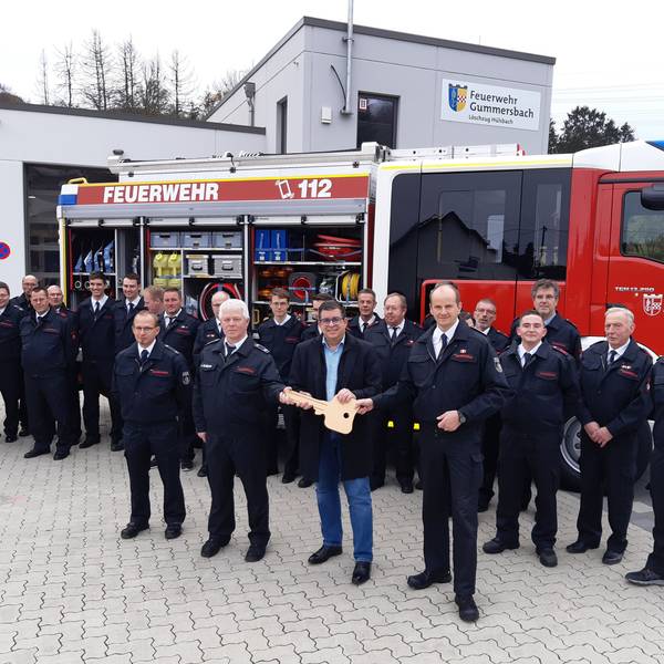 Bürgermeister Frank Helmenstein hält symbolisch für die Fahrzeugübergabe einen großen goldenen Schlüssel in der Hand. Diesen übergibt er an Feuerwehrchef Frank Raupach und die stellvertretenden Einheitsführer Stephan Schulte und Kai Alberts.