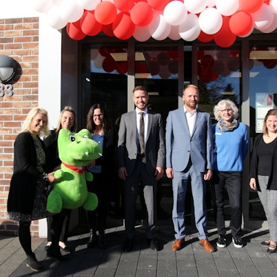 Mitarbeiter stehen vor dem Eingang der wiedereröffneten Filiale in Stommeln.