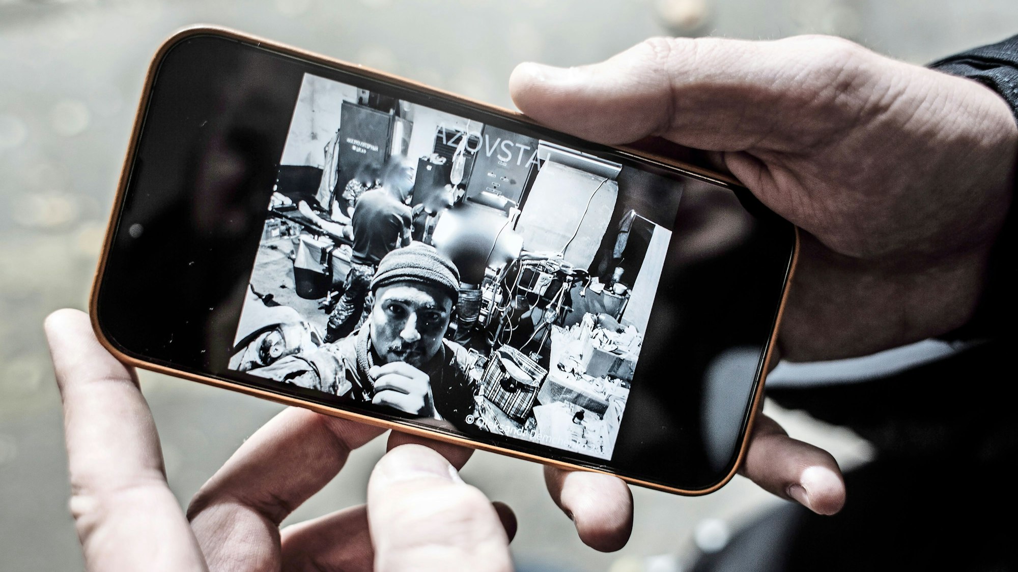 Oleksandr Demchenko zeigt ein Foto aus dem Asovstalwerk auf seinem Handy
