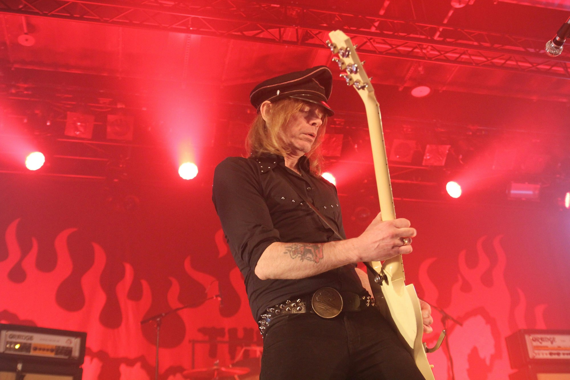 Der Hellacopters-Frontmann Nicke Andersson spielt auf der ganz in rotes Licht getauchten Bühne in Köln Gitarre.