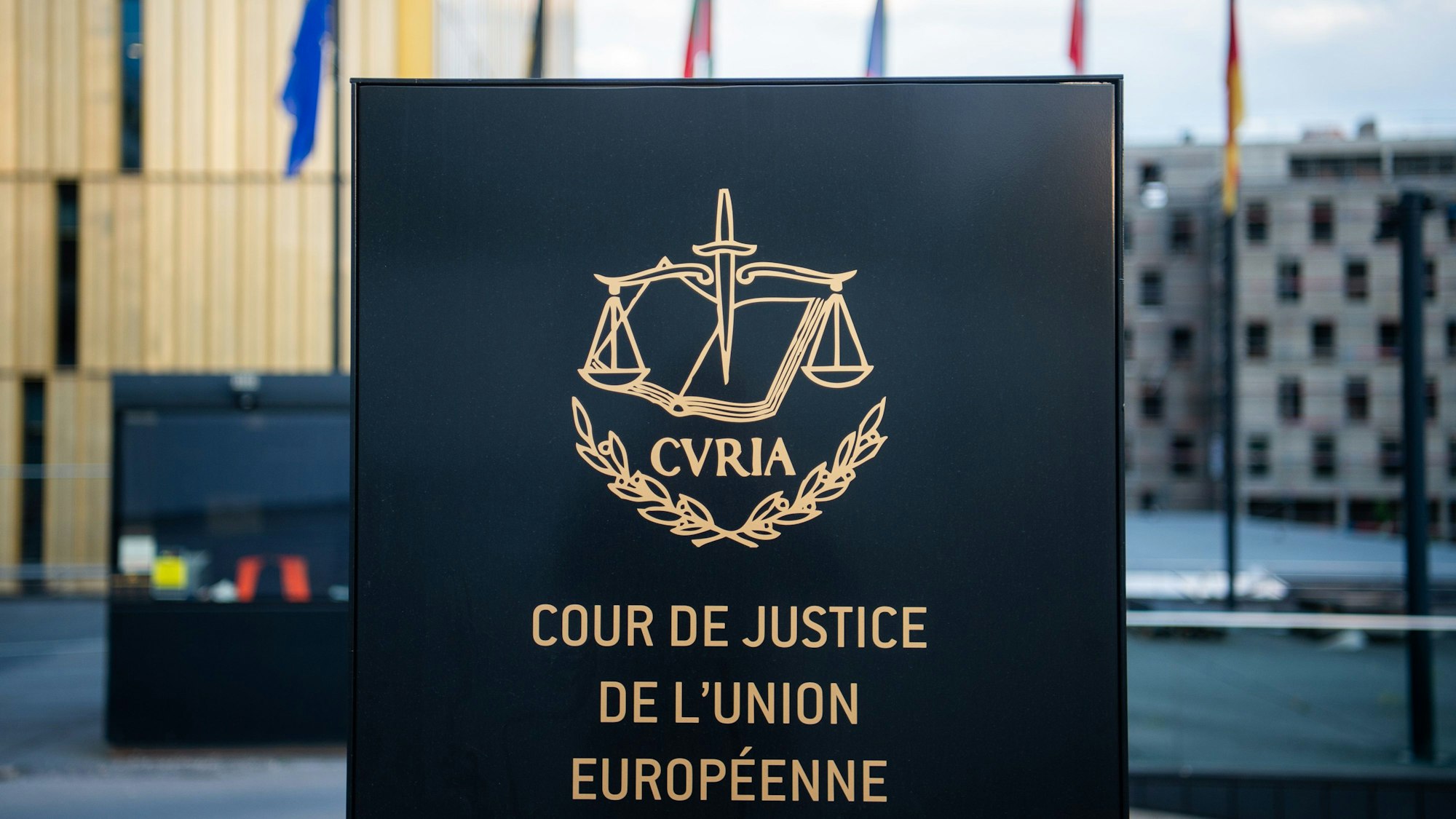 ARCHIV - 15.06.2019, Luxemburg: Ein Schild steht mit der Aufschrift «Cour de Justice de l'Union Européenne» steht vor dem Europäischen Gerichtshof (EuGH) im Europaviertel auf dem Kirchberg. Der EuGH fällt eine wichtige Entscheidung zur Speicherung von Verbindungsdaten bei Telekommunikationsanbietern. Die Telekom Deutschland GmbH und die SpaceNet AG wollen feststellen lassen, dass sie nicht verpflichtet sind, bestimmte Daten ihrer Kundinnen und Kunden auf Vorrat zu speichern. Foto: Arne Immanuel Bänsch/dpa +++ dpa-Bildfunk +++