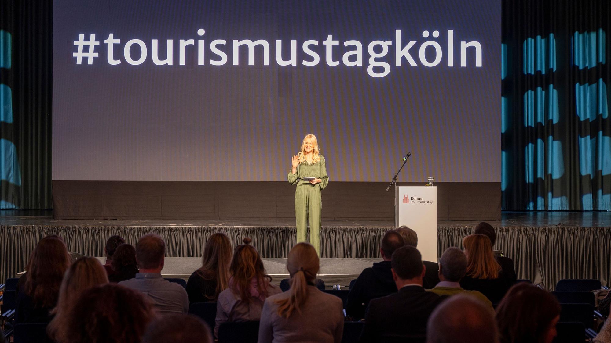Eine Moderatorin begrüßt die Gäste im Gürzenich.