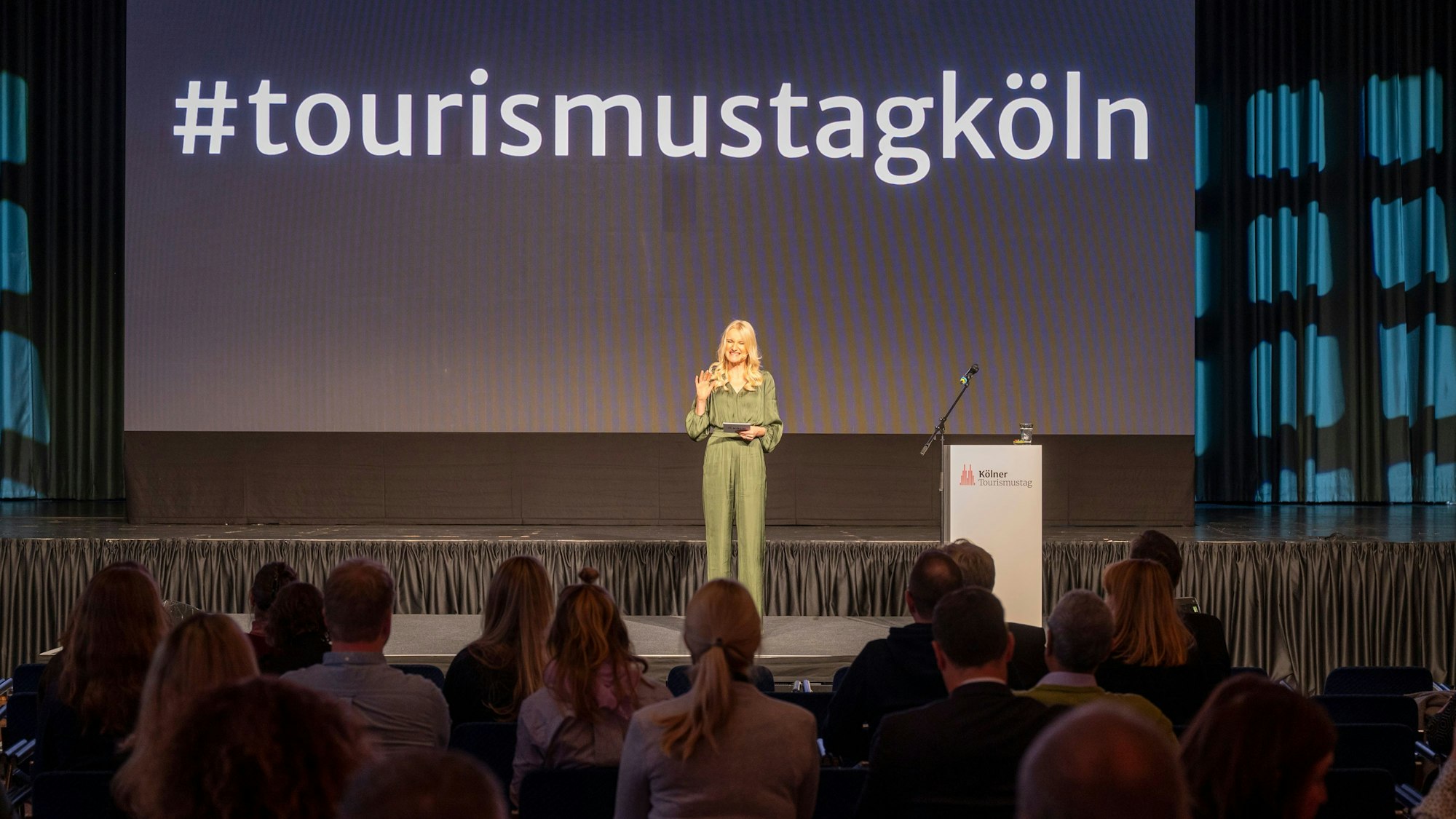 Eine Moderatorin begrüßt die Gäste im Gürzenich.