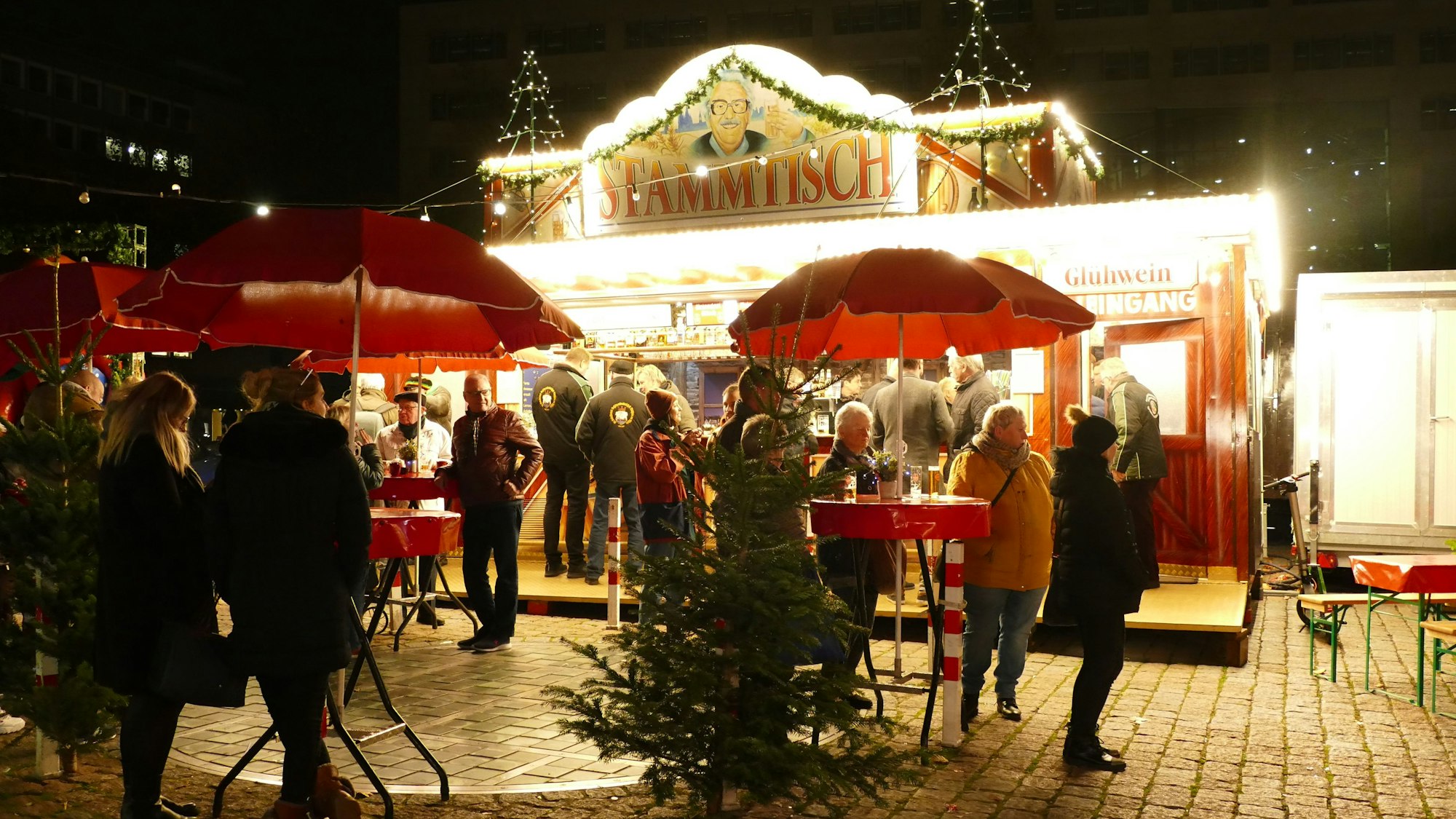 Die Glühweinhütte "Stammtisch" in voller Beleuchtung und mit Kundschaft.