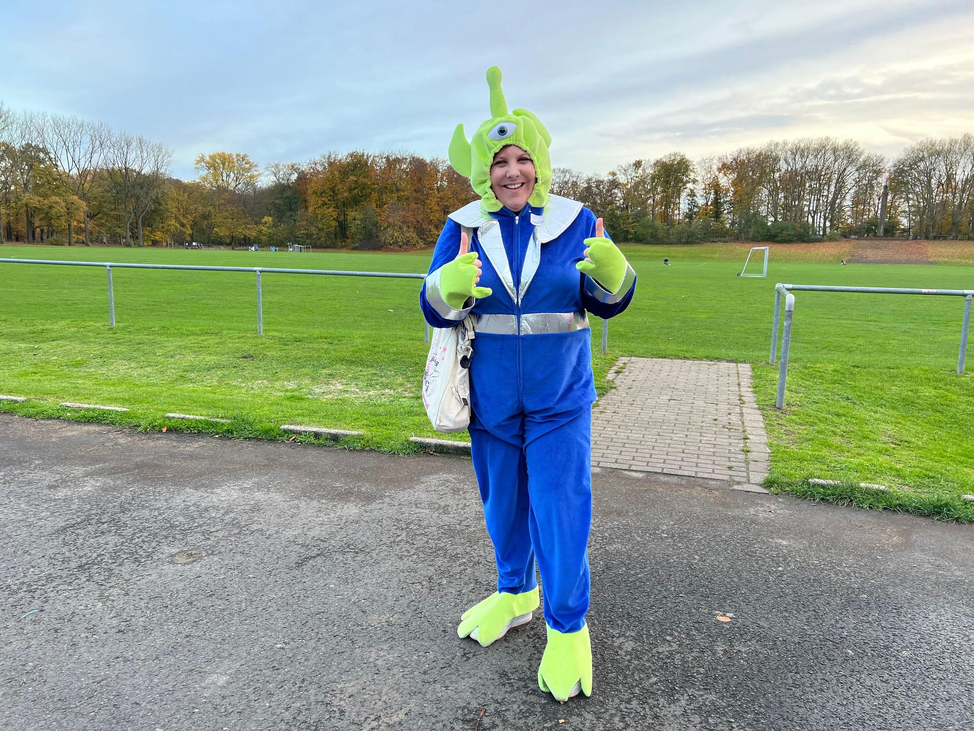 Die 33-jährige Angela Königstein aus Düsseldorf ist in einem blau-grünen Alien-Kostüm zum Musivideodreh von Influencer Twenty4tim nach Köln gekommen.