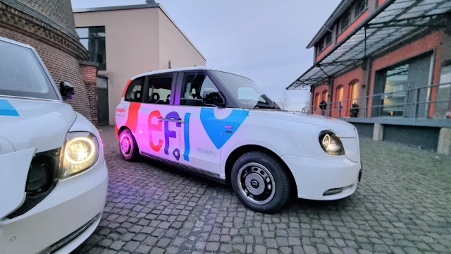 Ein Efi-Kleinbus mit Platz für sechs Fahrgäste steht auf dem Platz vor dem Funkenturm in Opladen.