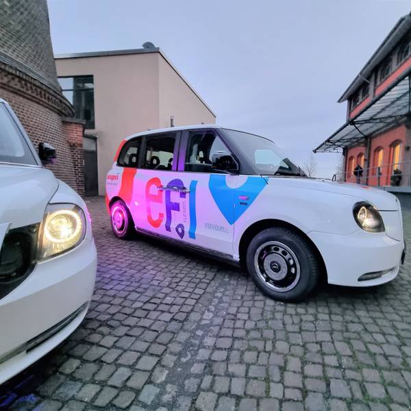 Ein Efi-Kleinbus mit Platz für sechs Fahrgäste steht auf dem Platz vor dem Funkenturm in Opladen.