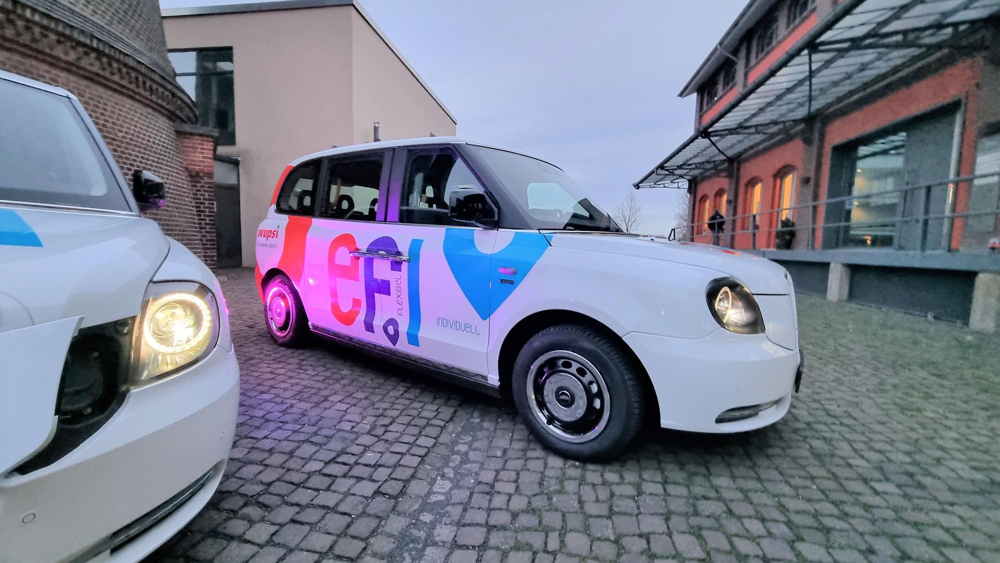 Ein weißes Efi-Fahrzeug steht auf einem gepflasterten Weg.